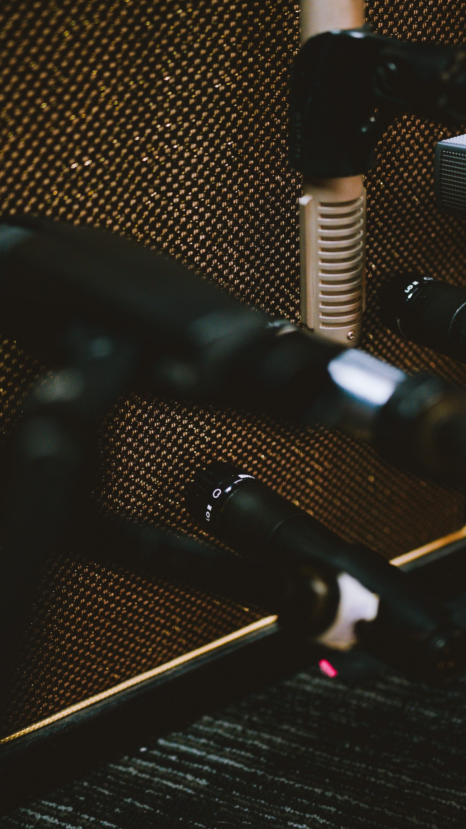 Ribbon and dynamic microphones set up against an amp grille